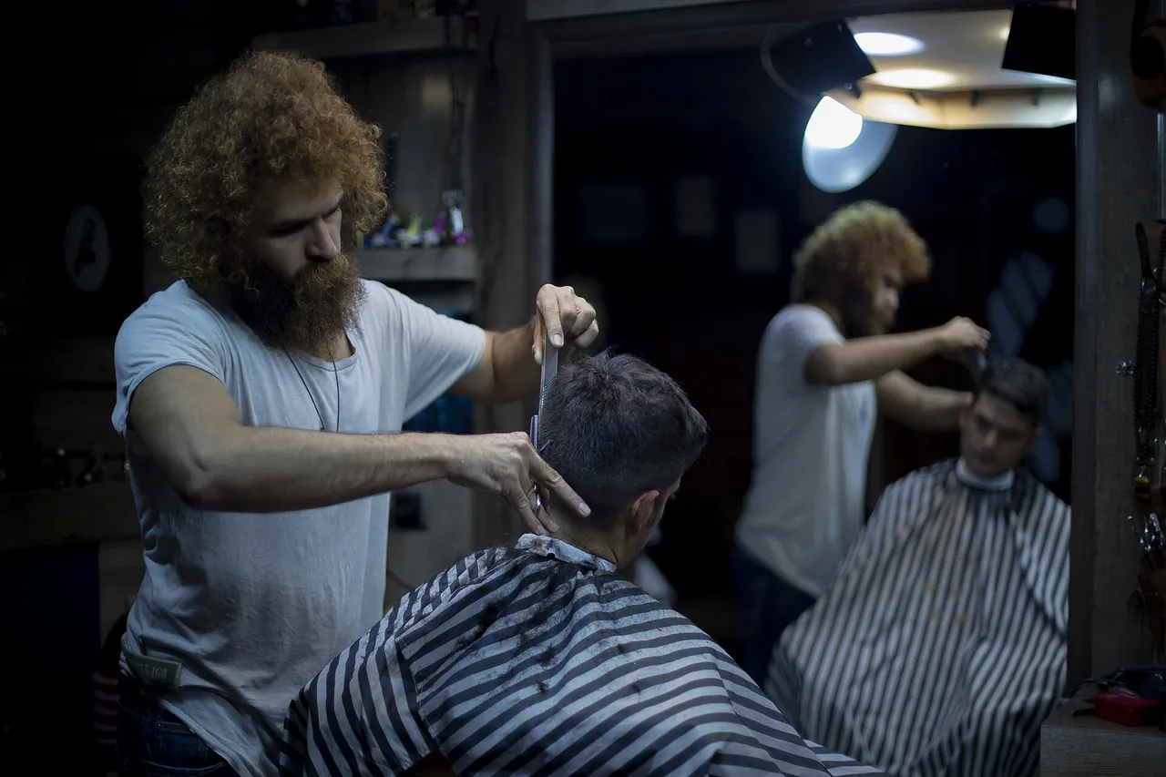 Barbero cortando el pelo a un cliente en su local