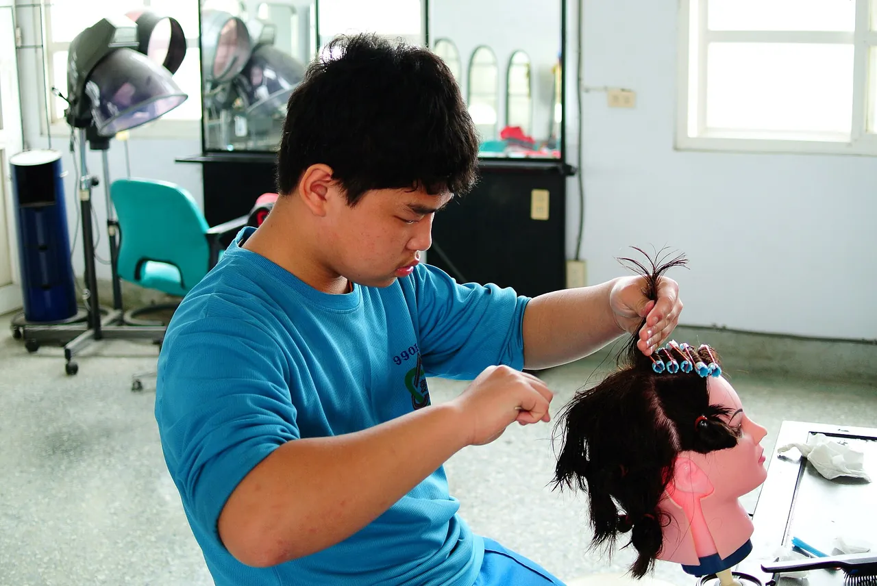 Estudiante de peluquería practicando con un maniquí en clase